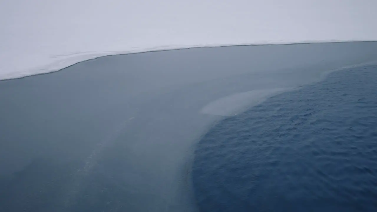 Snow-Covered Shoreline In A Peaceful Lake During Cold Winter Season