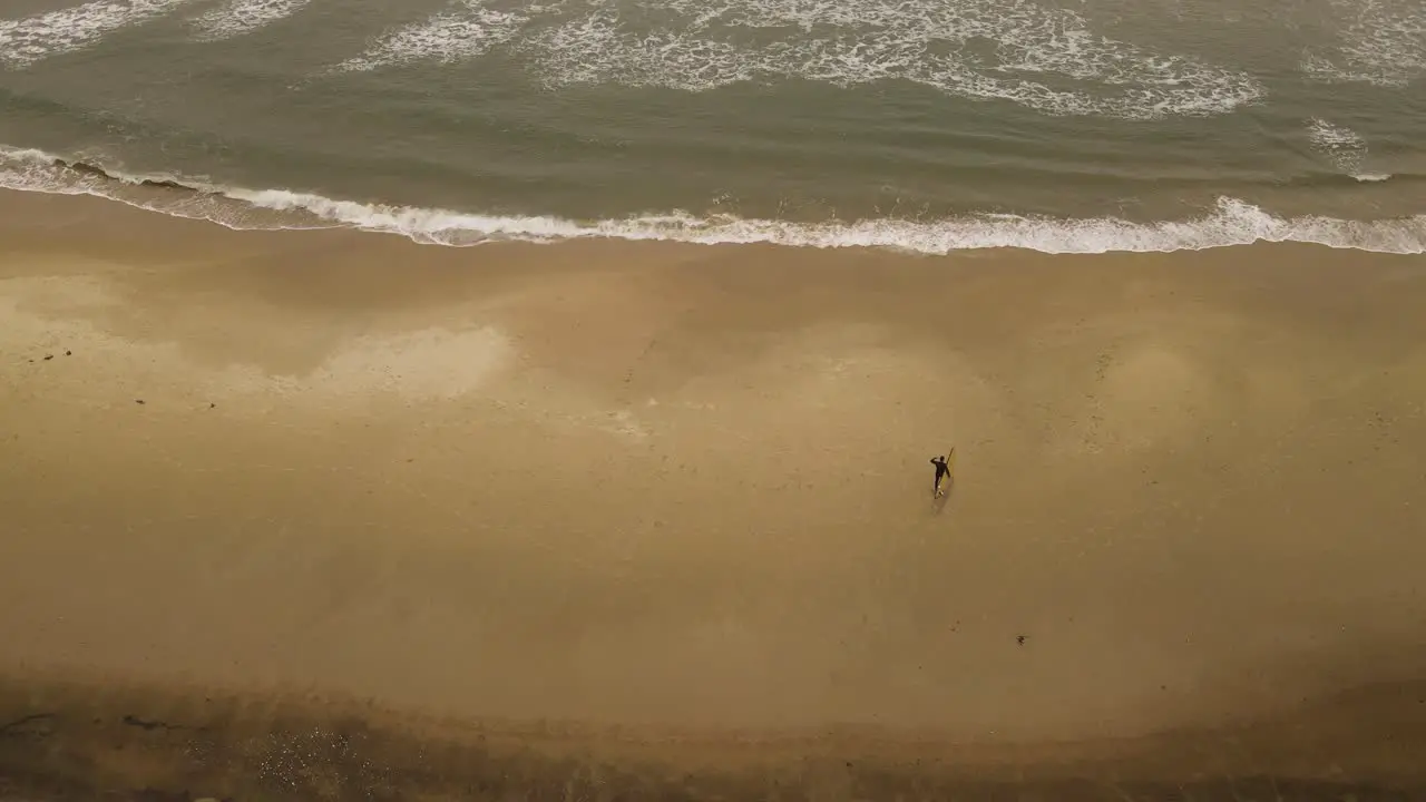 Slow-motion of surfer walking on La Pedrera beach before entering Atlantic ocean waters Uruguay