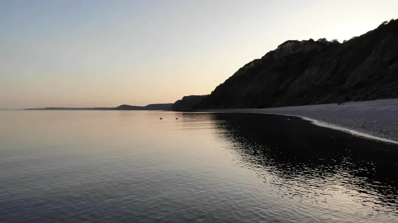 Aerial Above Calm Tranquil Sunset Waters Beside Littlecombe Shoot Beach