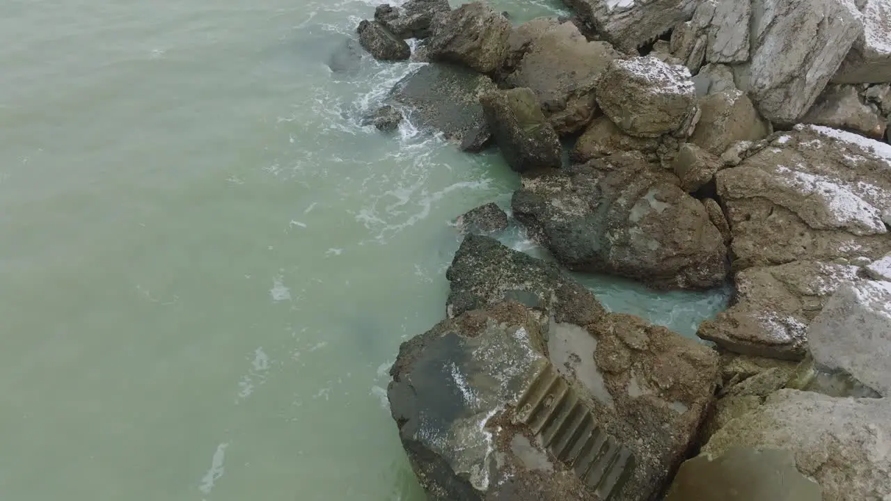 Aerial birdseye view of abandoned seaside fortification buildings at Karosta Northern Forts on the beach of Baltic sea  overcast winter day drone shot moving forward