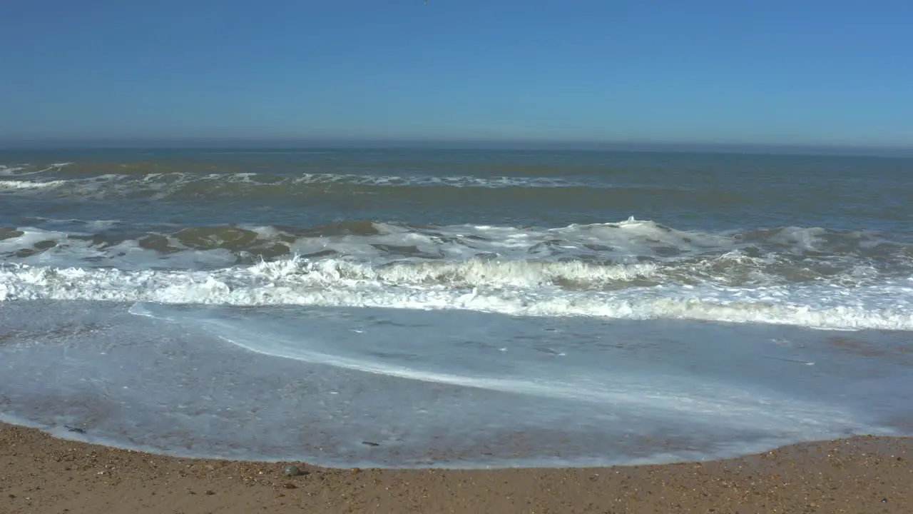 Standing shot over-watching the calming steady beautiful waves crashing on the beach