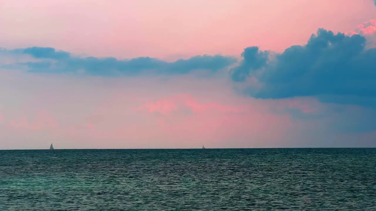 Distant sail boat sailing at sunset on the