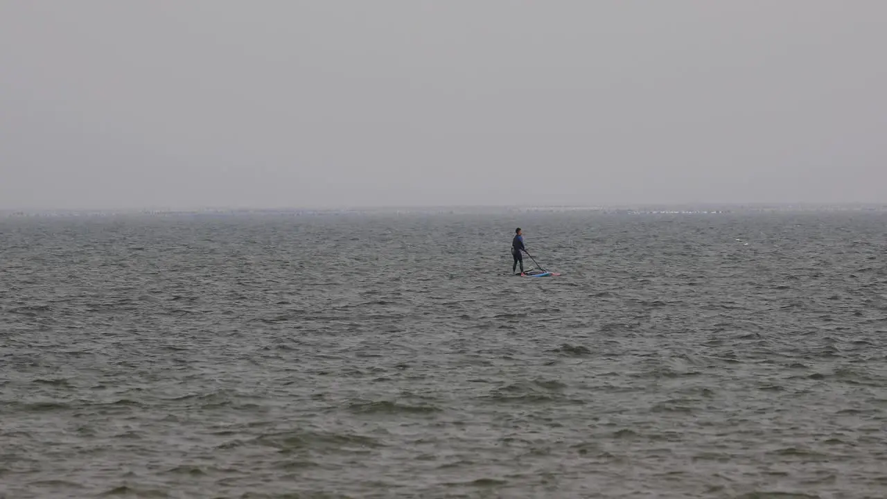 Wind Surfer Trying to Pull his Sail up in the Water on an Overcast Day in Pattaya Thailand