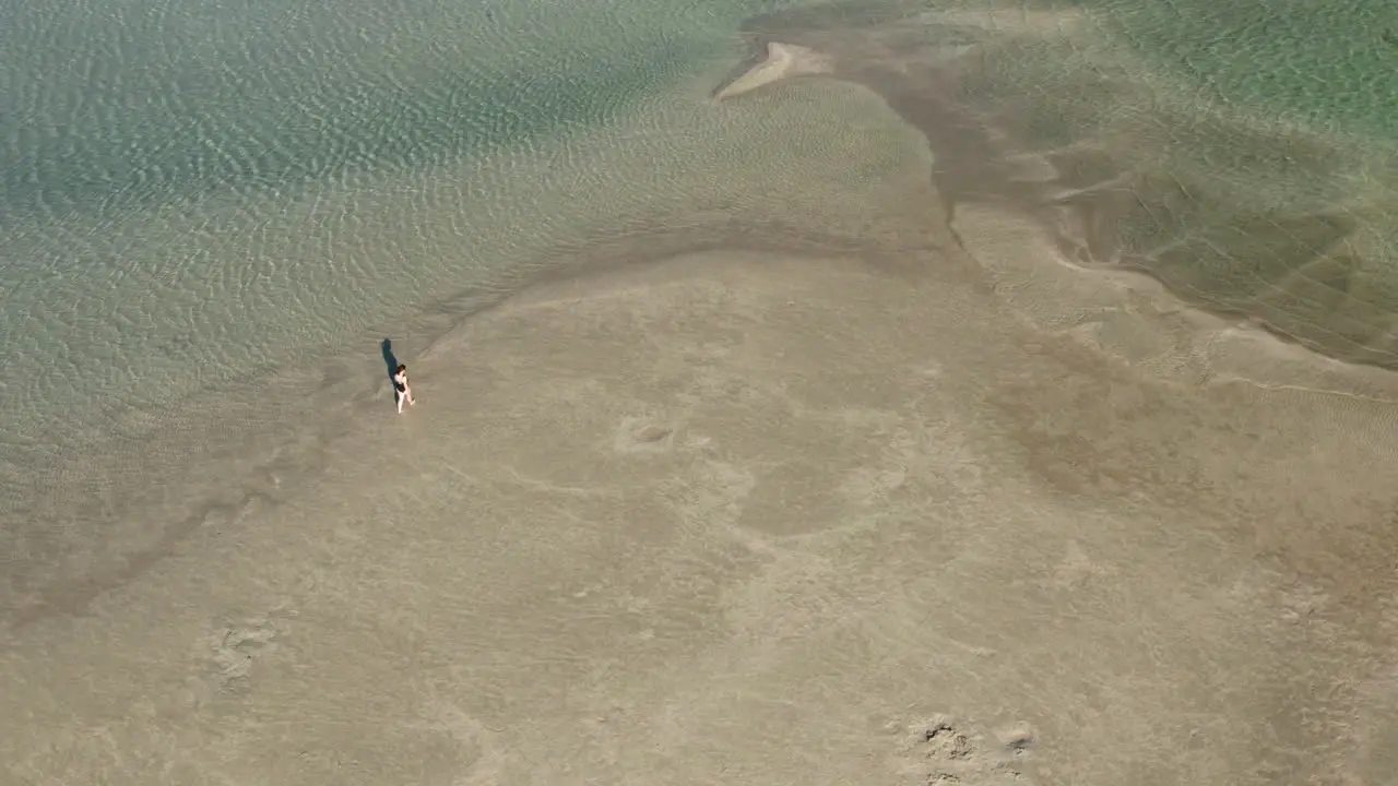 Top View Of A Woman Walking Along The Calm Elafonissi Beach On Sunny Day In Crete Greece