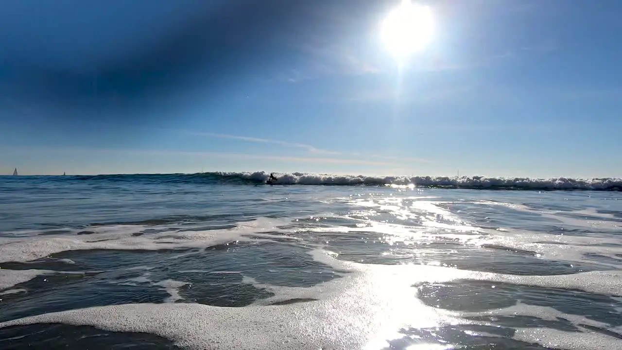 Waves crash over the camera and a surfer falls at Venice Beach in LA