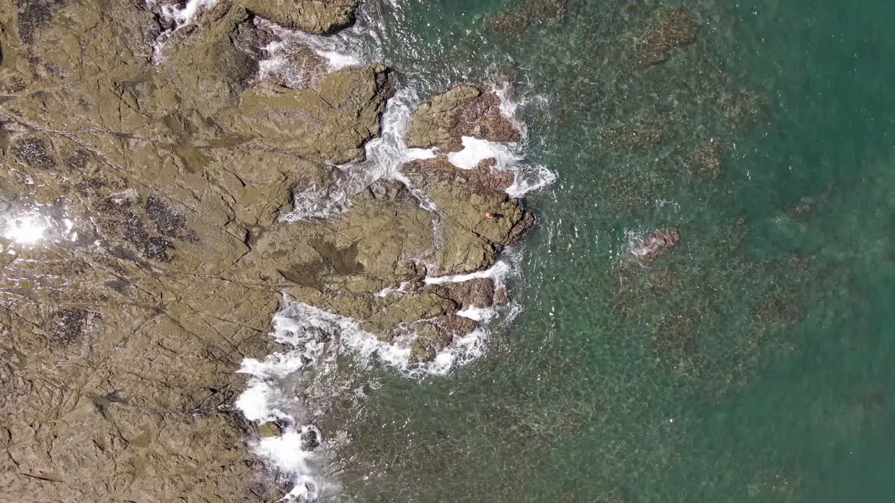 Slow Ascending Shot Of Waves Battering Off The Rocks At The Shorefront