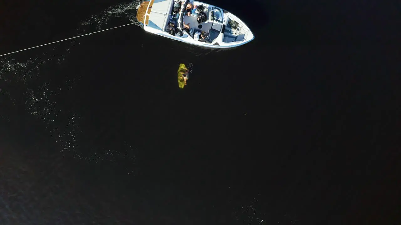 The boat picks up wakeboarder in the water drone footage