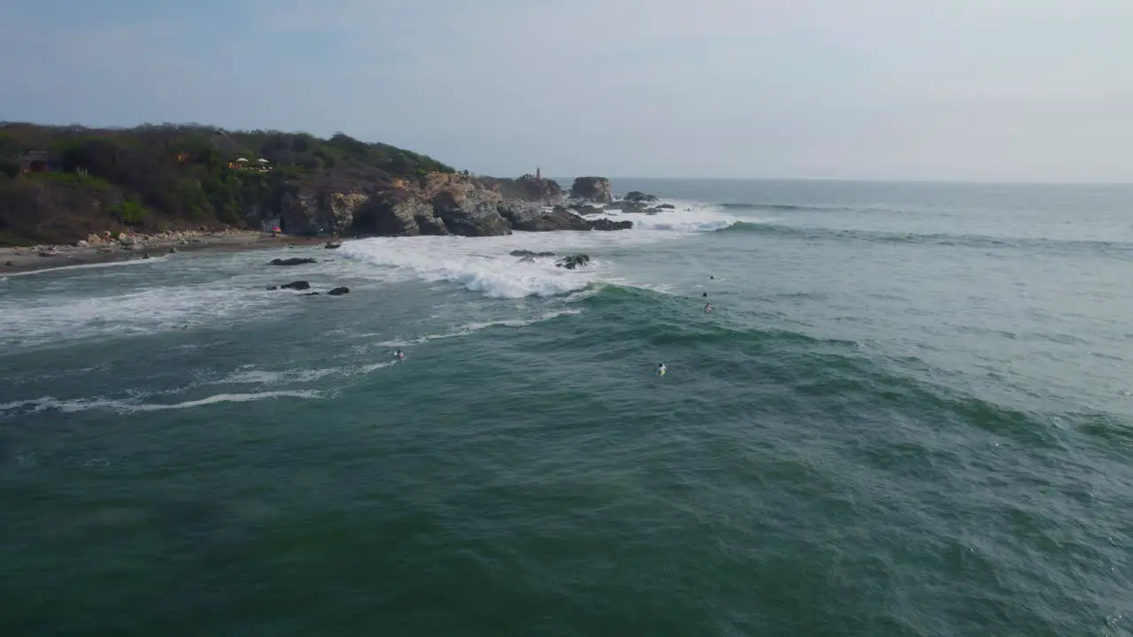 Aeria shot of a surfer riding a wave with others waiting