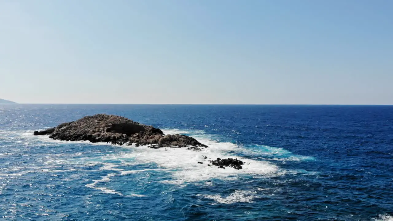 Seascape With Foamy Waves Splashing On Rocks At Jerusalem Beach In Greece aerial drone shot