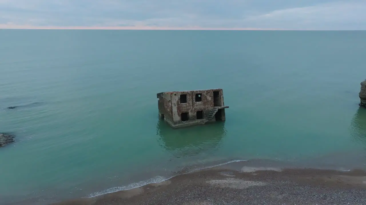 Aerial view of abandoned seaside fortification buildings at Karosta Northern Forts on the beach of Baltic sea  overcast day wide drone shot moving forward tilt down