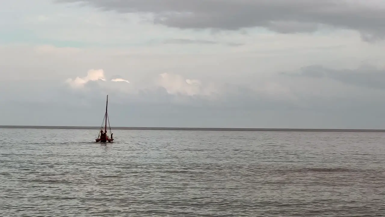 Silhouette of a vintage sailboat just offshore in Hawaii on a calm day static view with no sail up