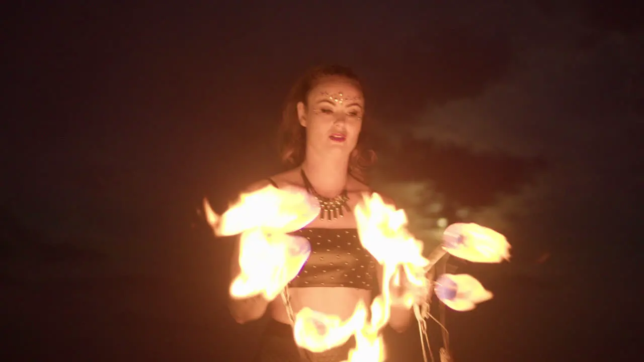 Woman Igniting Second Fire Fan Against Cloud Covered Moon Medium Shot Slowmo