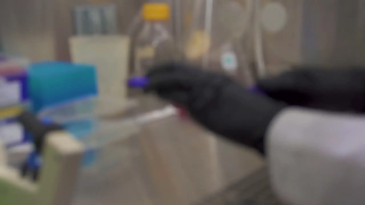 blurry clip of a scientist writing on tissue culture flasks