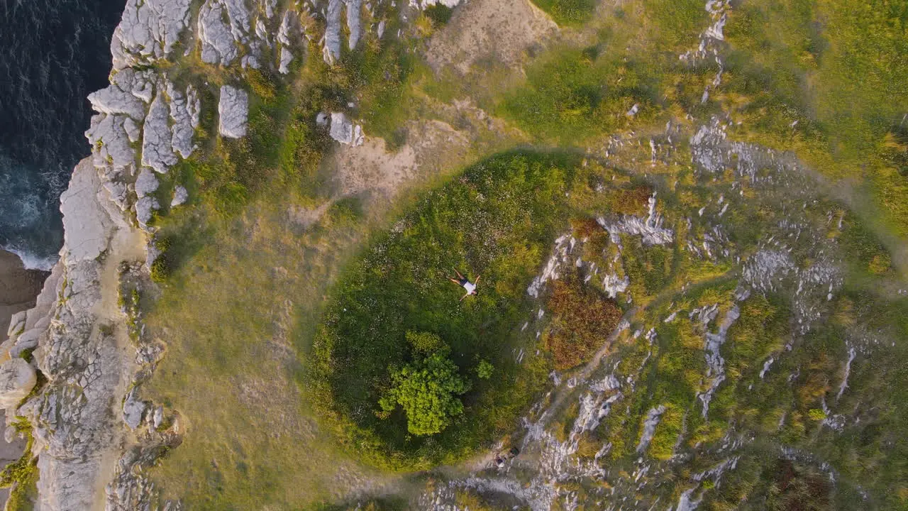 Vergrößern Sie Einen Mann Der Am Rand Einer Klippe Einer Felsigen Küste Liegt Und Sich Entspannt