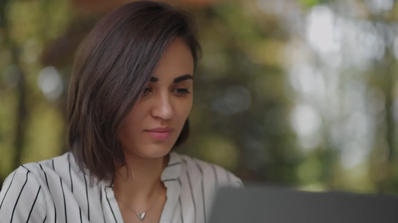 Retrato Mujer Seria Morena Grupo étnico Hispano Se Sienta En Una Mesa En Un Café De Verano Con Una Computadora Portátil Escribe En El Teclado Y Recibe Capacitación En Línea Compra Y Negocia Con Un Banco De Internet