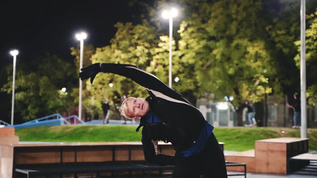 Hombre Rubio Deportivo Haciendo Ejercicios De Estiramiento Antes De Entrenar En El Parque Por La Noche