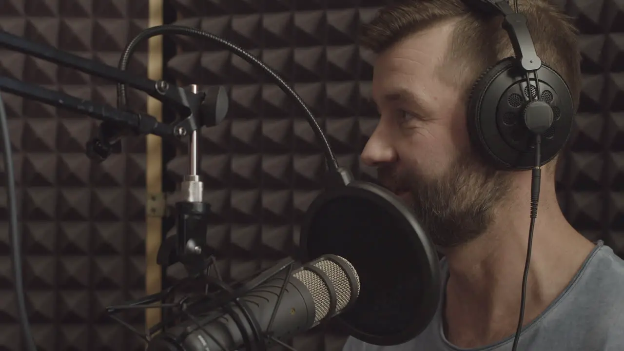 Un Presentador De Radio Con Barba Habla A Través Del Micrófono En Un Estudio De Radio