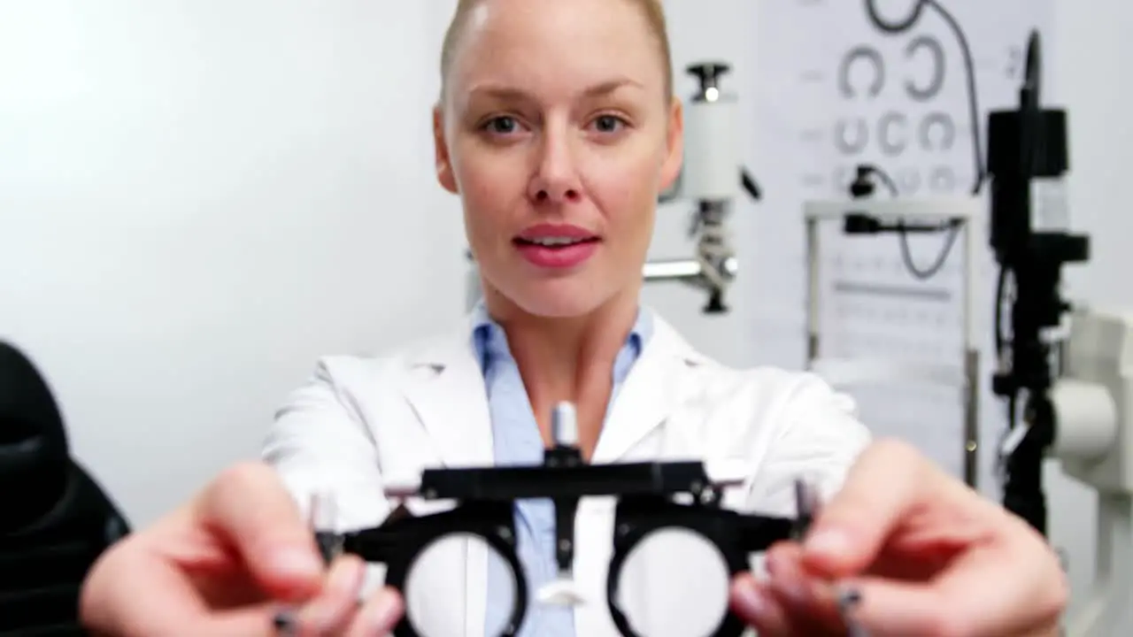 Smiling female optometrist holding messbrille