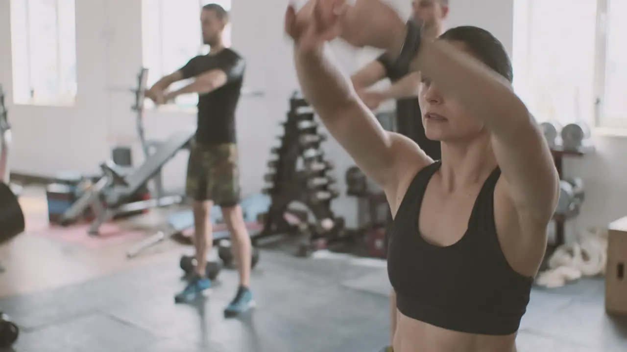 A Strong And Athletic Young Woman Does Arms And Shoulders Stretching Exercises In The Gym