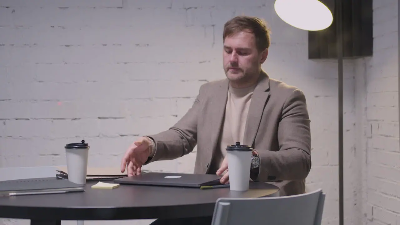 Stressed Businessman Closing Laptop Computer And Leaving The Meeting Room