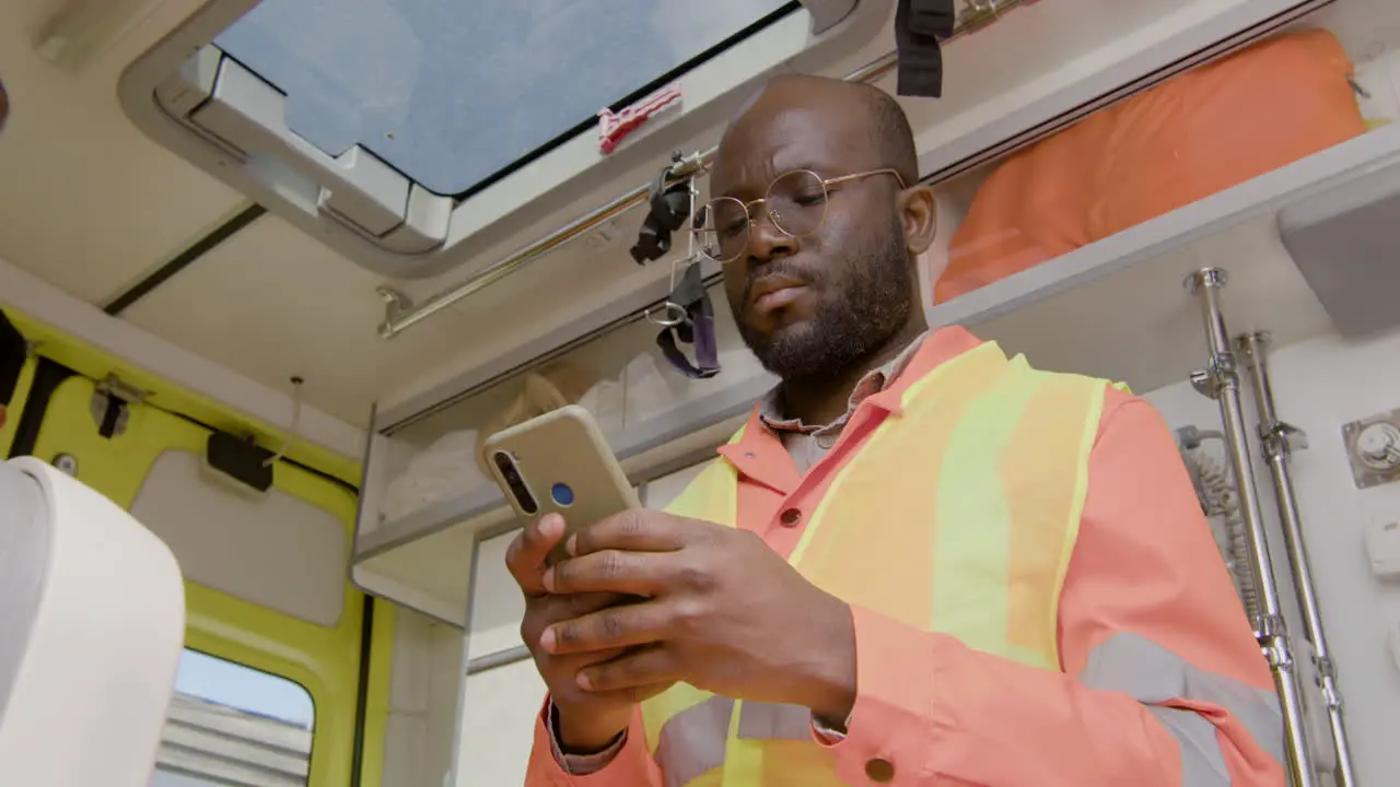 Close Up Of American Medical Assistant Texting And Using His Smartphone