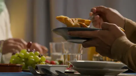 Person Serving Samosas At Muslim Family Table At Home Set For Iftar Meal Breaking Daily Fast During Ramadan