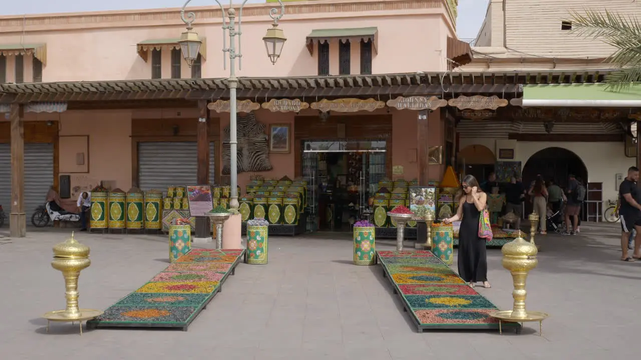 tourists taking photo of decorative Moroccan panels in front of herb shop