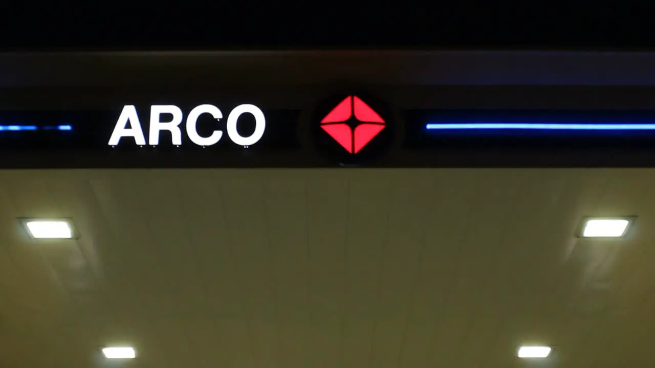 Pan Down from Arco Gas Station Sign to AMPM Convenience Store Night