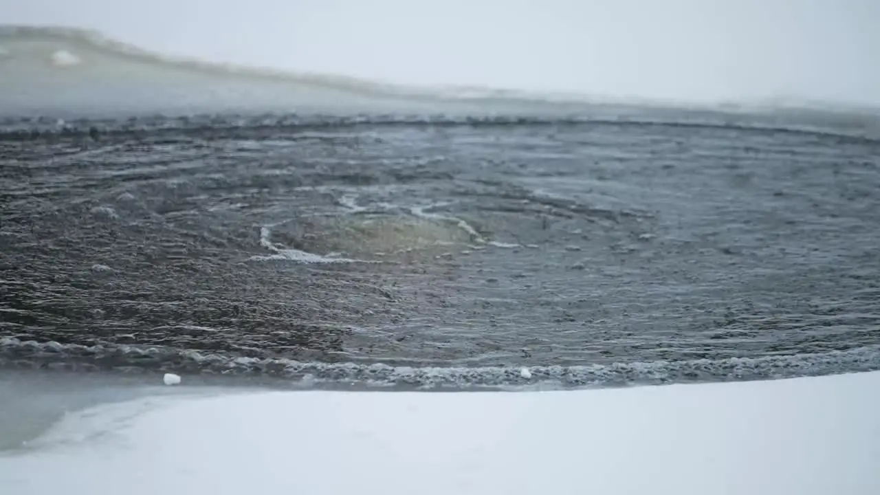 Slow motion shot of boiling water in an ice hole in southern Estonia