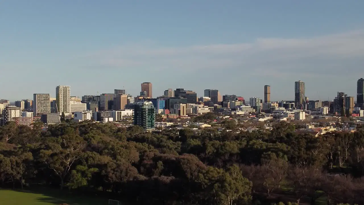 Drone shot of the Adelaide CBD moving right to left with the Adelaide Parklands in the foreground