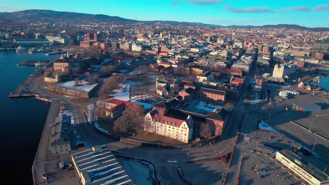 Oslo Aerial drone at waterfront Central train station opera and Akershus Fortress along the seaside fjord Norway during sunset