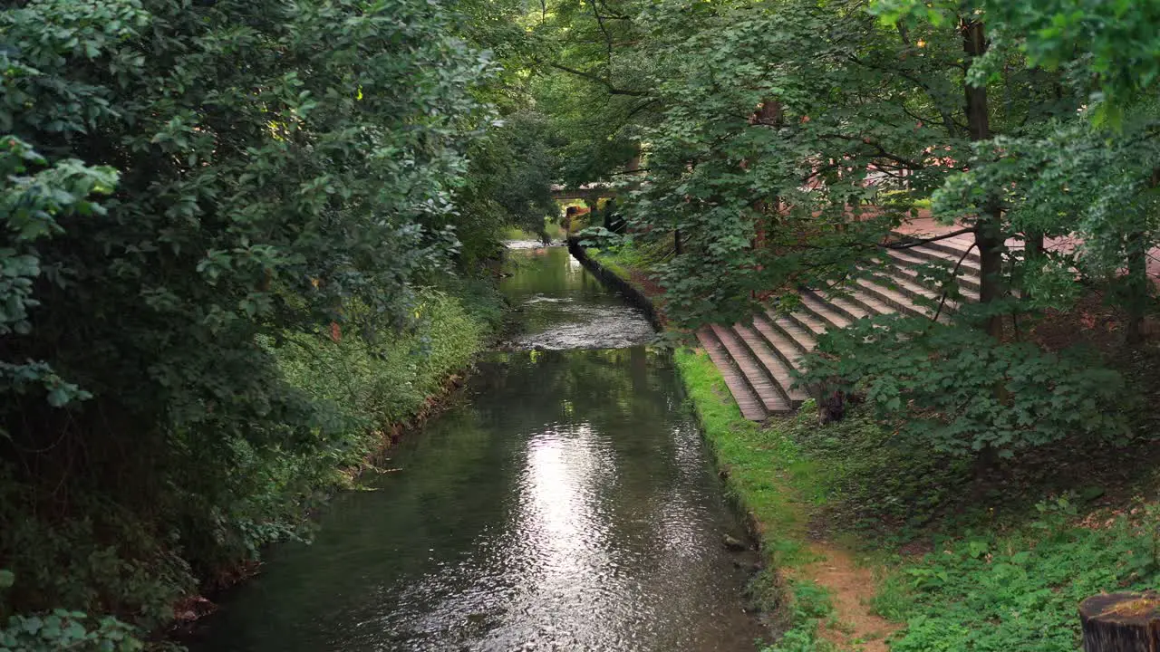 A river flowing through a city full of greenery in a hot summer