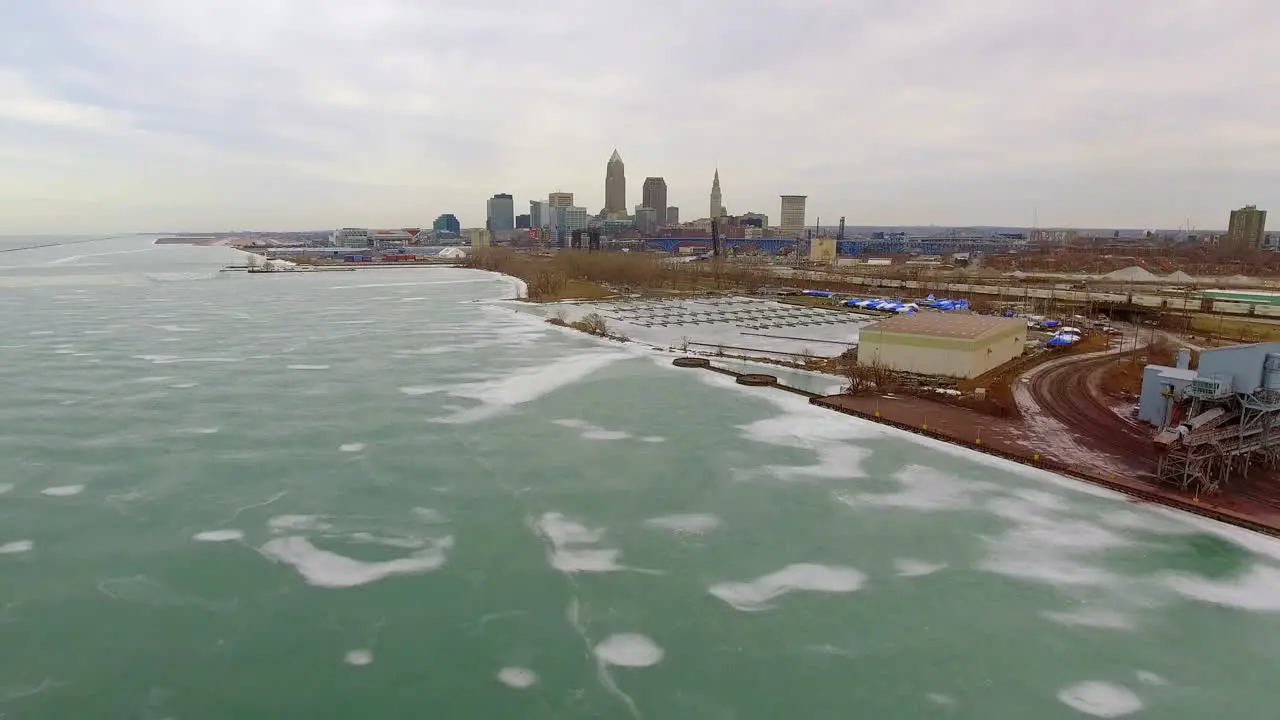 Wide revealing drone shot of downtown Cleveland Ohio and a frozen Lake Erie