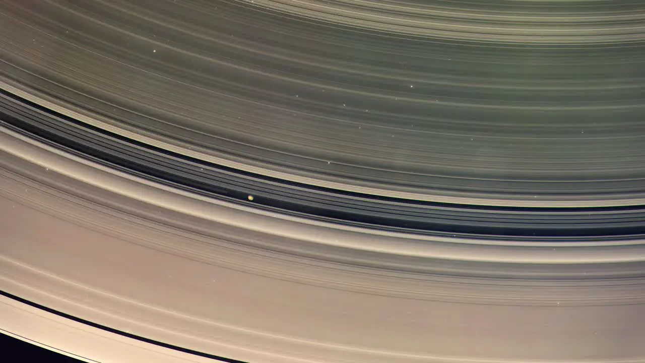 Close Shot of a Moon Orbiting Within the Rings of the Gas Giant Saturn