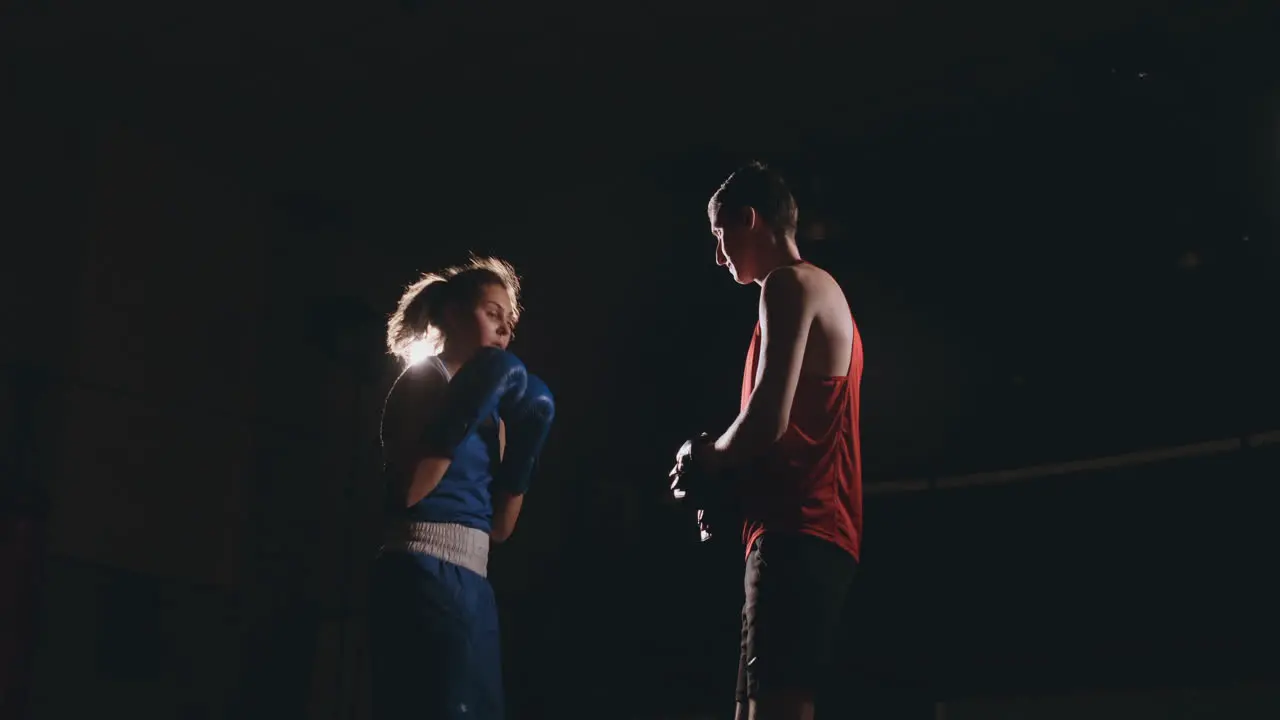 Young adult woman doing kickboxing training with her coach