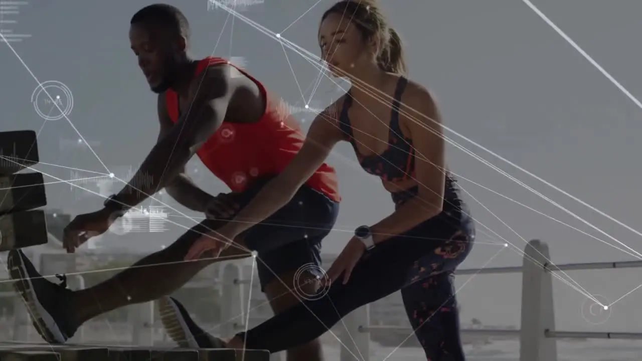 Network of connections against mixed race couple performing stretching exercise on the promenade