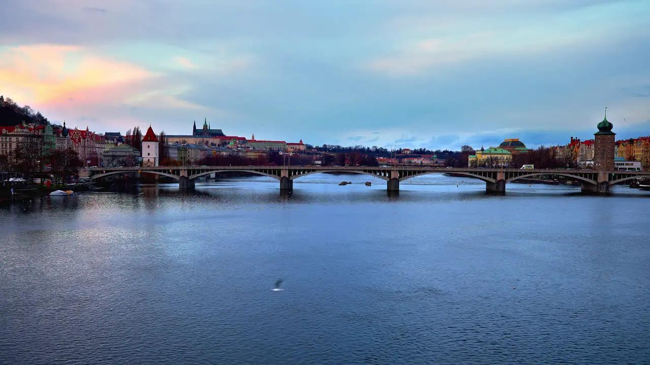 Jirásek bridge over Vltava river in Prague with city skyline at dusk