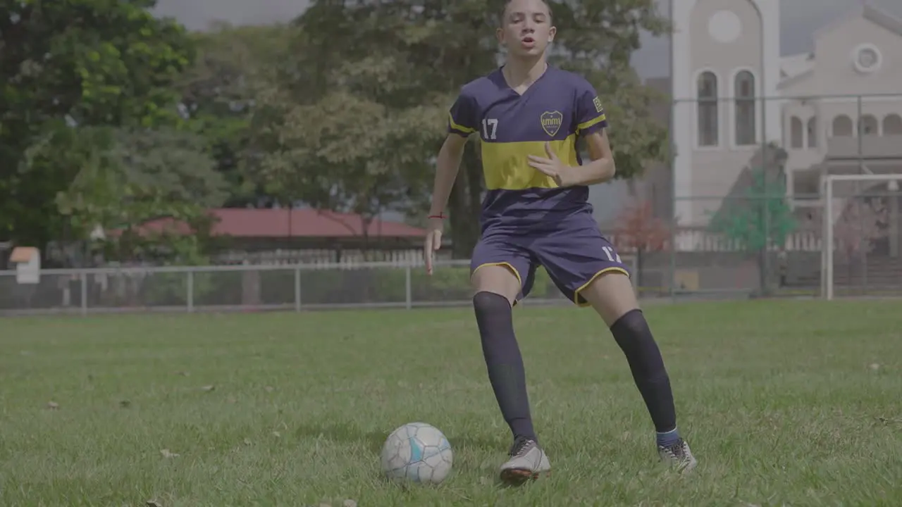 young man training soccer with a ball in the field