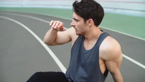 Portrait of tired man resting after running workout on track Exhausted runner