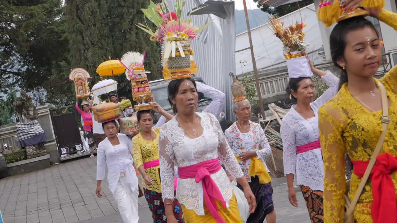 Ladies in traditional wear going to Bali religious event in temple