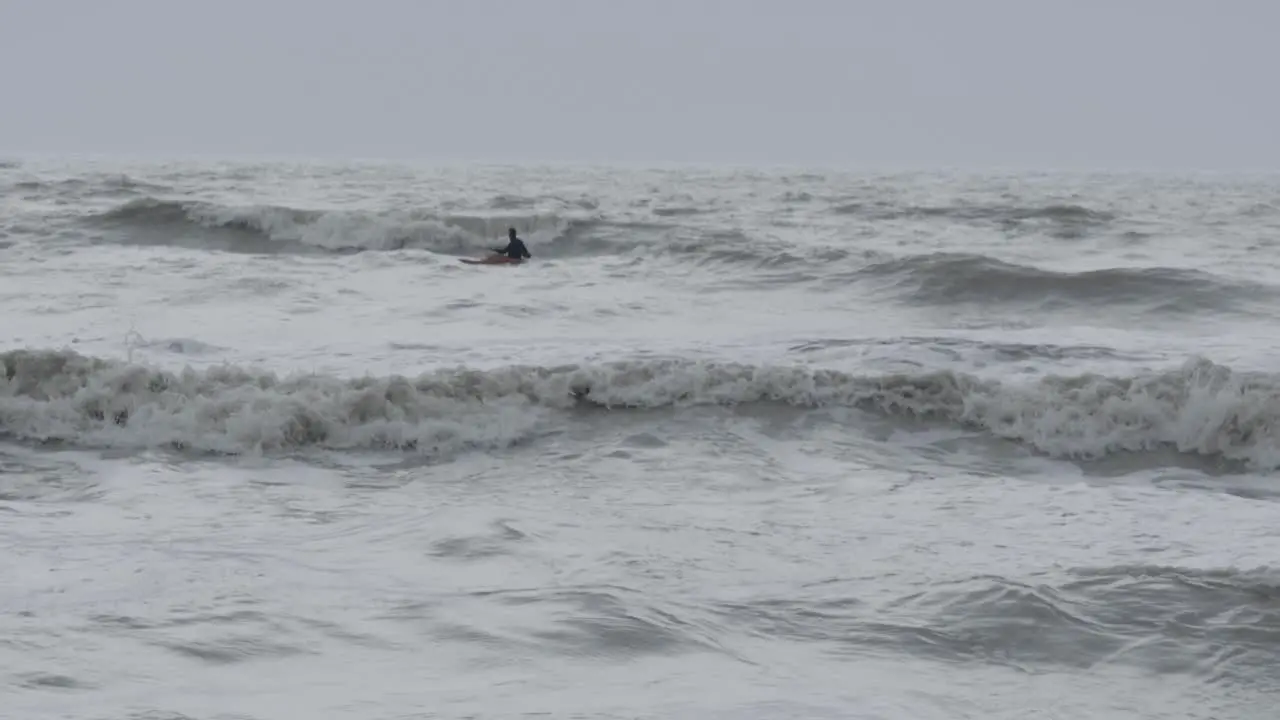 Man kayaking in a stormy sea