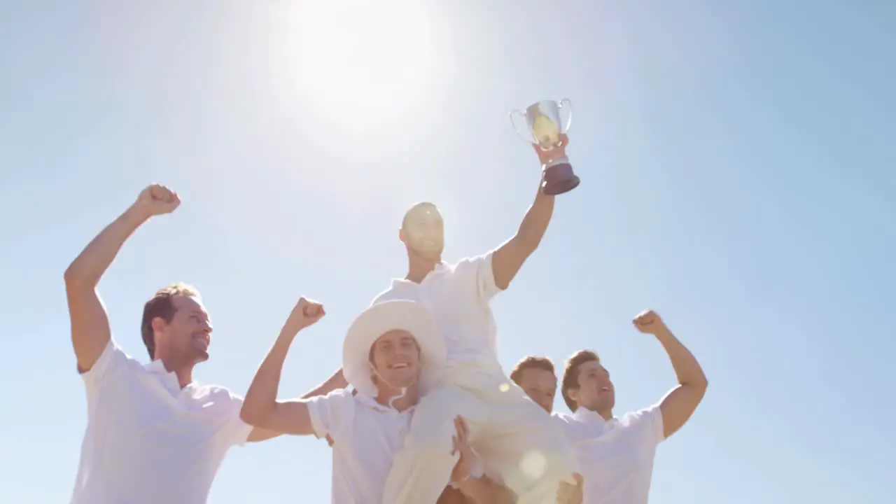 Cricket team with trophy on cricket field