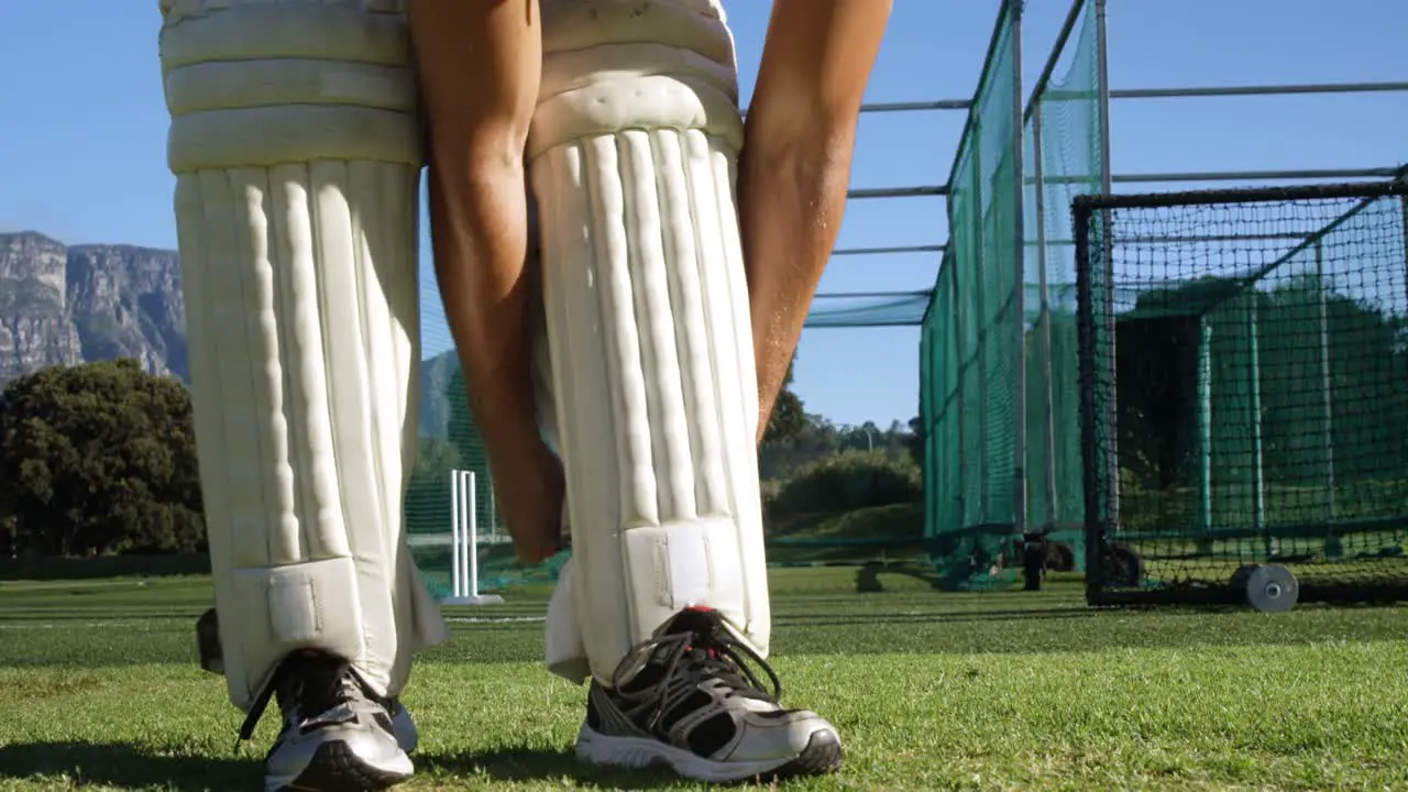 Cricket player tying his batting pads during a practice session