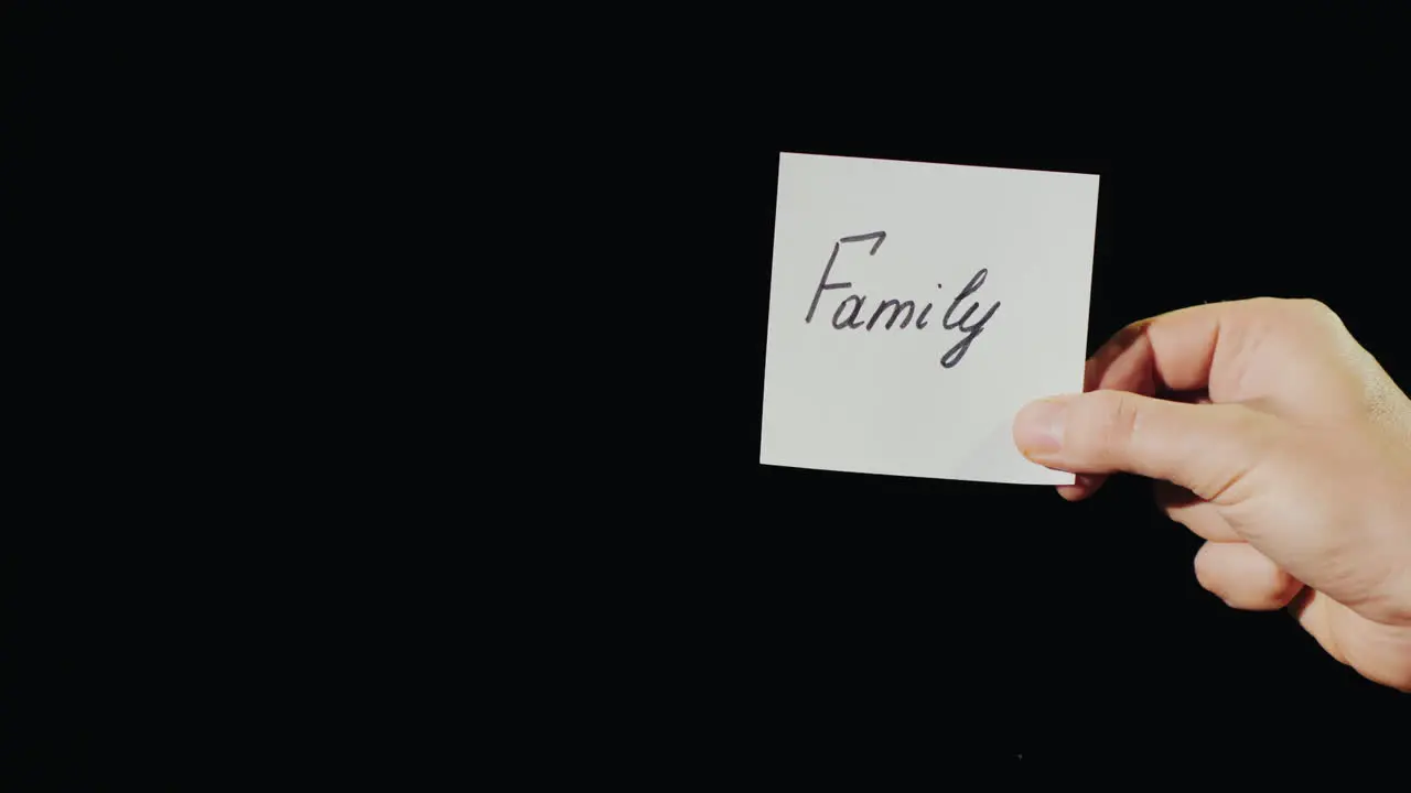 Hand Holds Burning Paper With Inscription Family