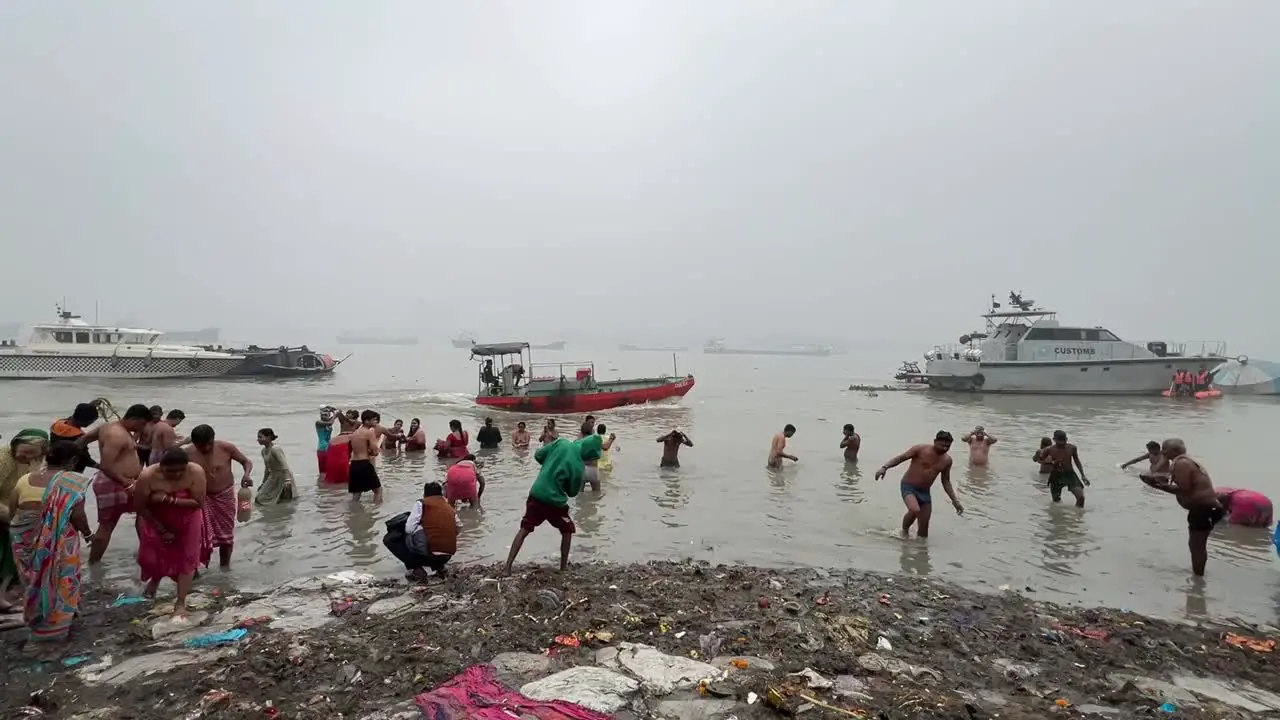 Cinematic shot of Hindus bathing at Ganges river in Babu Ghat Kolkata for the celebration of Sankranti festival