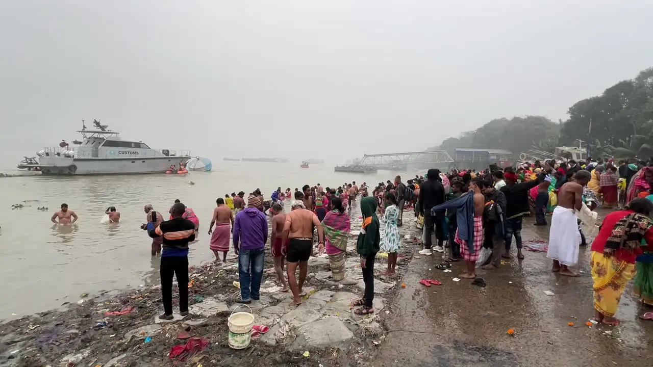 Side wide angle view of Hindus bathing in Babughat Kolkata for the celebration of Sankranti festival during evening 