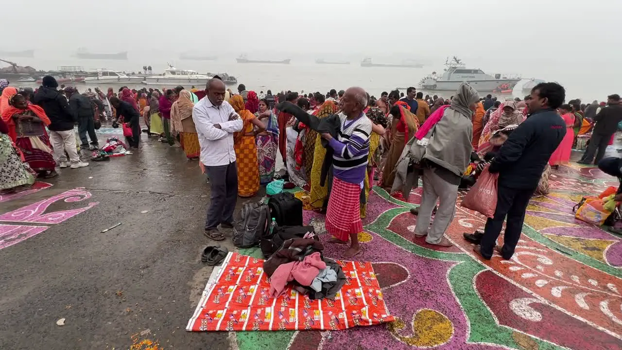 Cinematic view of Indians taking shower on Ganges river in Babu Ghat for religious purposes for Sankranti festival in Kolkata India