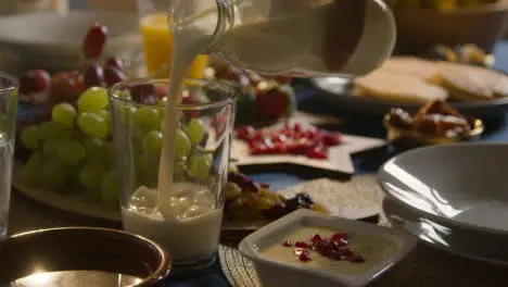 Muslim Family Table At Home Set For Iftar Meal Breaking Daily Fast During Ramadan With Milk Being Poured