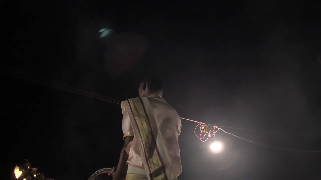 Indian Man Waving Ceremonial Candelabra