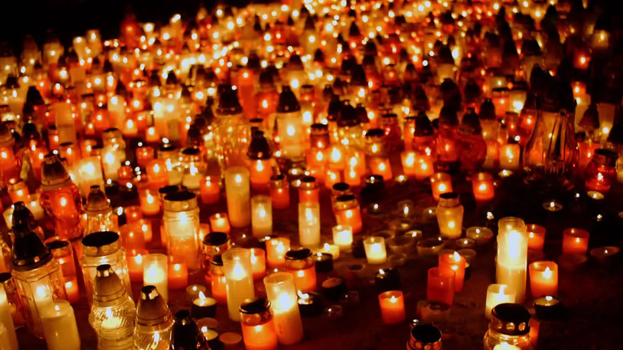 Many candles on the ground in cemetery during ceremony